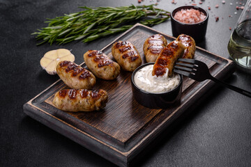 Grilled sausage with the addition of herbs and vegetables on the dark background