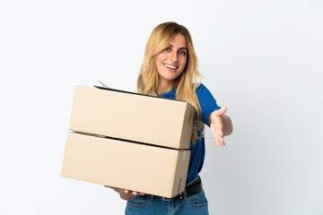 Young blonde Uruguayan delivery woman isolated on white background shaking hands for closing a good deal