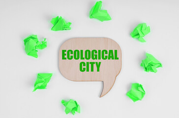 On a white background, there are crumpled green pieces of paper and a wooden sign with the inscription - Ecological City