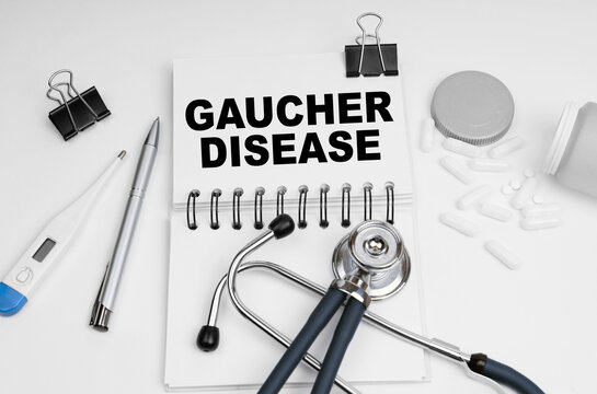 On the table are a stethoscope, pills, a thermometer and a notebook with the inscription - Gaucher Disease