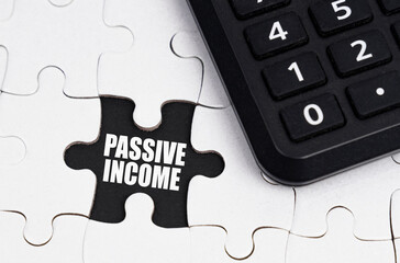 There is a calculator on white puzzles, an inscription in an open cell - Passive income