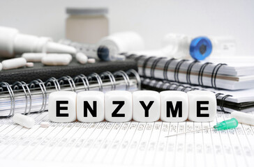 On the table are diaries, medicines and cubes with the inscription - ENZYME