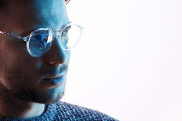 Male in glasses with futuristic holographic interface to display data. Portrait of beautiful young man. Augmented reality, future technology, internet concept.