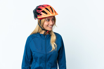 Young blonde Uruguayan cyclist woman isolated on background looking to the side and smiling