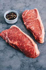 Raw New York striploin beef steak isolated on gray background