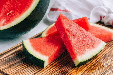 Sliced ripe watermelon on wooden board, close-up.