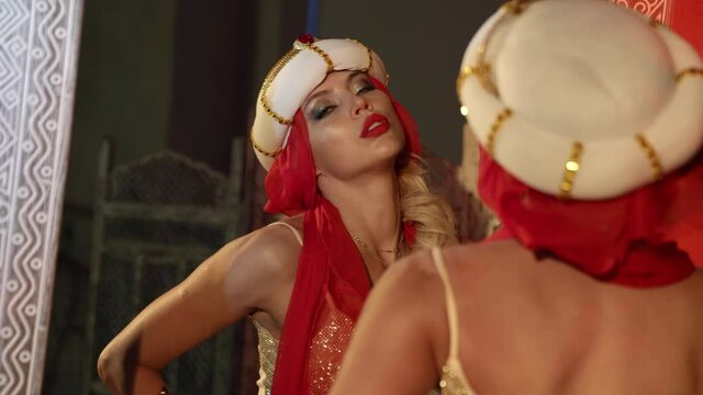 sexy sultana is viewing herself in mirror in palace, alluring body and face of blonde pretty woman