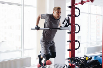 Athlete man in the gym doing elevations. Caucasian male training in the gym during the day