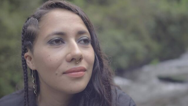 Bella y joven mujer latina contemplando y disfrutando del r&iacute;o en el bosque 