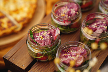 serving salads in portions in small glass jars. buffet for the holiday. 