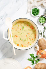 Homemade chicken and dumplings with carrots, peas and potatoes in a white baking dish