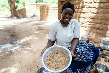 Closeup of a satisfied housewife showing a big plate of traditional African cereals and vegetables