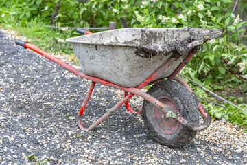 Iron wheel barrow for moving of building materials in the garden and in the backyard