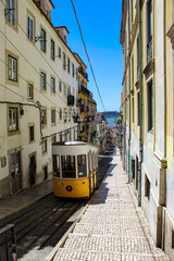 Vintage tram in the city center of Lisbon in a beautiful summer day, Portugal. Traditional yellow tram on a street in Lisbon, Portugal.