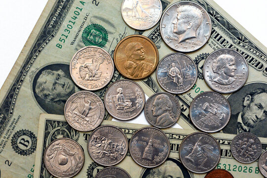 Background of old American dollars banknotes of different values 1dollar bill, 2 dollars and 5 dollars with American coins of different values 1 cent, 25, 50 cents and 1 US dollar coins isolated 