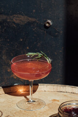 jam cocktail with rosemary spring in coupe glass