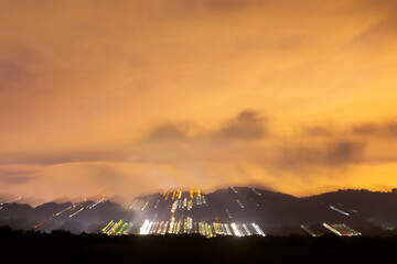 Night covered with clouds, storm and rain on the horizon light sweep, paint with light in the darkness of the city.