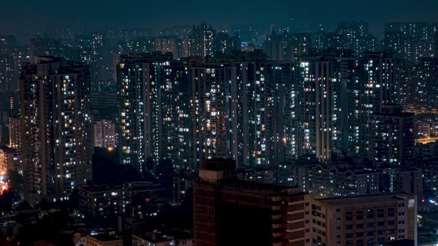 Night city apartments time lapse loop. Chinese crowded city with lights turning on and off at midnight. Fast paced modern Asian night-scape time lapse in urban metropolis.