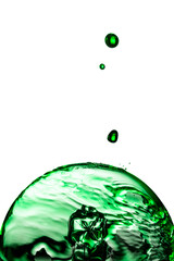 Liquido verde caindo sobre uma lâmpada de vidro.