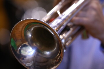 Close up of a trumpet.Silver shiny musical instrument fuzzy abstract background.Concept image shout...