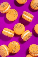 Orange homemade macarons isolated on a bright purple background