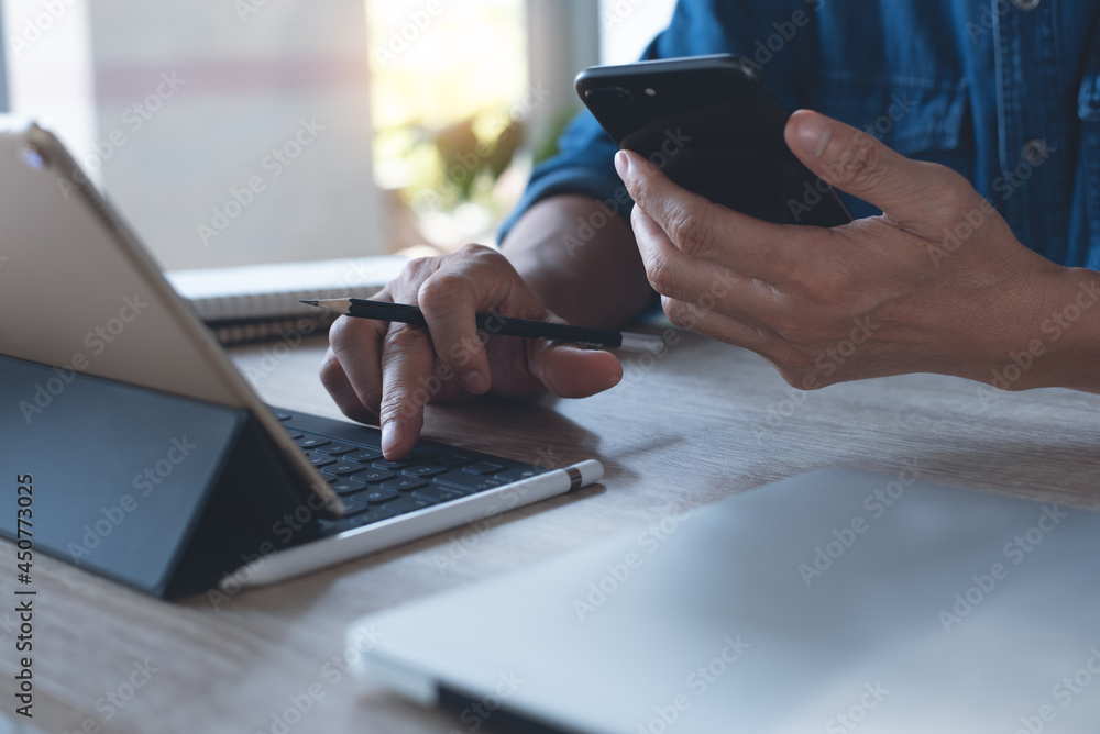 Poster multitasking business man using mobile phone during working on laptop computer and digital tablet on