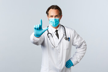 Covid-19, preventing virus, healthcare workers and vaccination concept. Serious confident doctor in...
