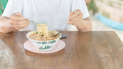 Obraz na płótnie Canvas Asian man eating instant noodles
