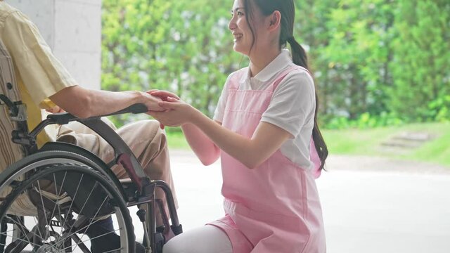 車いすに乗ったお年寄りと話す介護ヘルパー