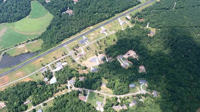 Aerial shot of airport runway passing by houses in Saxapahaw, North Carolina, USA