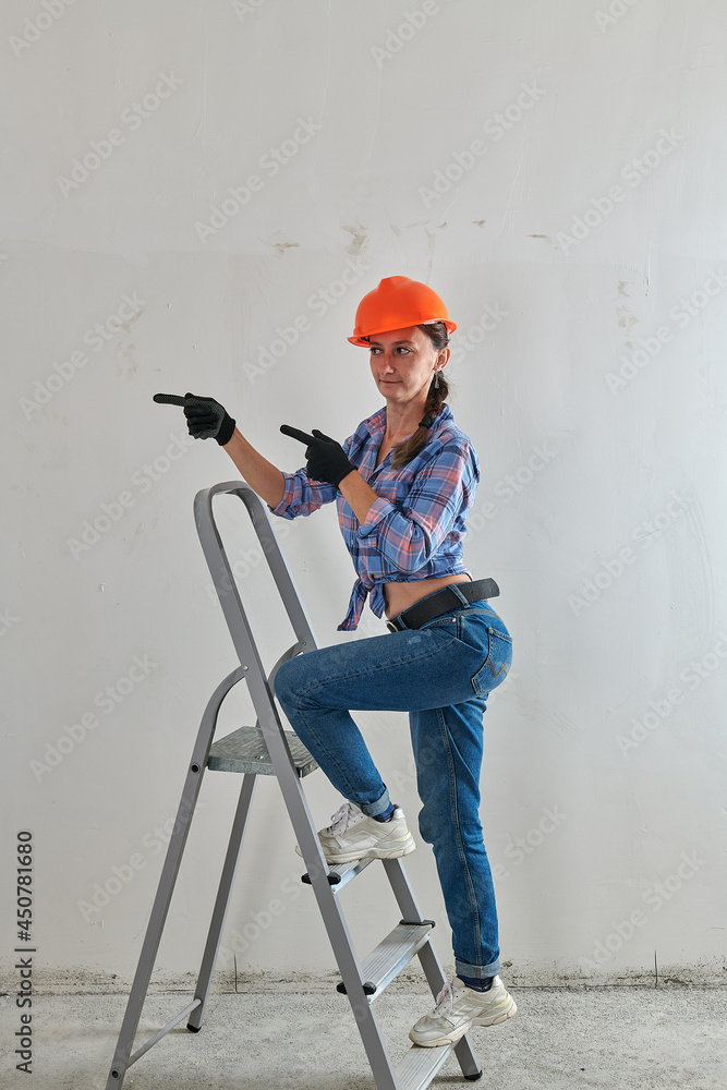 Wall mural a girl makes repairs in an apartment on a stepladder