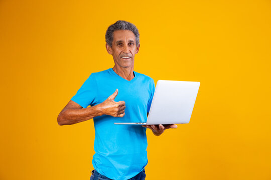 Elderly Man With Laptop Shopping Or Working Online. Older Man With His Thumb Up Holding A Notebook Computer.