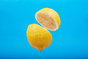 sliced lemon on a blue background with levitation effect, artistic fruit