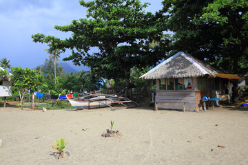 traditional Filipino bangka boat and wooden hut on a beach in the Philippines. Romblon