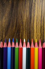 Lapices de colores sobre un fondo color cafe, hechos de madera. Crayones de color.