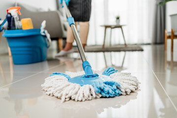 Close up, Housekeeper wearing protective gloves using mop cleaning floor in living room at home,...