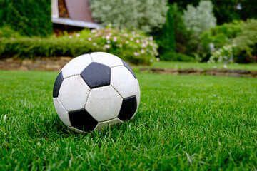 Close-up view of football ball on green grass lawn