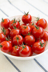 Fresh Red Organic Cherry Tomatoes in a Bowl, side view. Close-up.