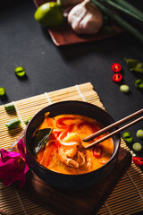 Coconut soup with shrimps and rice pasta. Hot bowl of exotic soup.