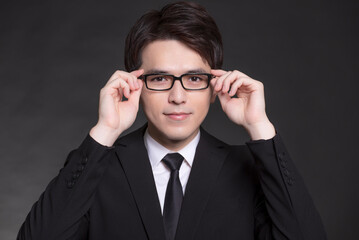 Young buisnessman in black suit and wearing eyeglasses