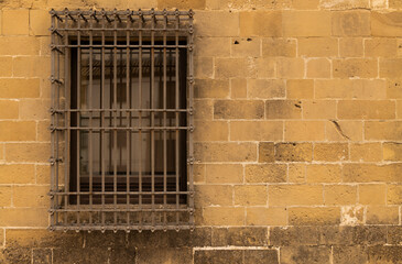 Fototapeta na wymiar Closeup of a window and stone wall in Baeza, an old town in Jaen province, Andalusia, Spain