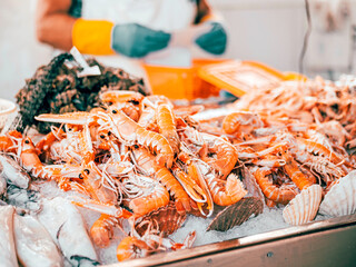 Fresh fish and crabs and sea food for sale on a block of ice in a popular local fish market