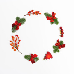 Christmas round frame from natural green fir branches and small red glitter balls and berries o