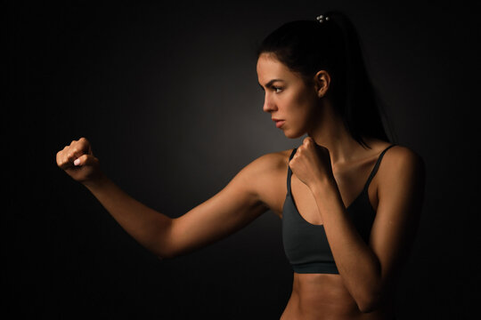 Sportsman, woman boxer fighting without gloves on black background. Boxing, mma and fitness concept.