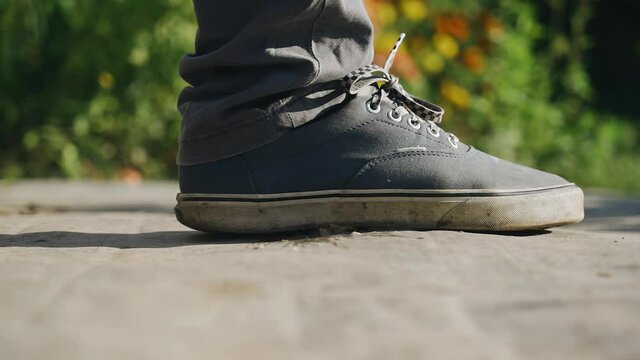 A man crushes an apple fruit lying on the ground with his whole foot. Slow-motion frames