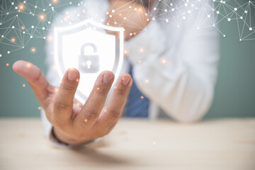 A young businessman holding a shield with a padlock icon in his hand connects to wireless internet around the world. concept of safety cybersecurity, protection computer.