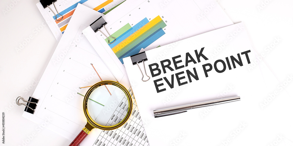 Aufkleber break even point text on white paper on the light background with charts paper