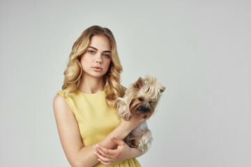 woman in a yellow dress fun a small dog isolated background