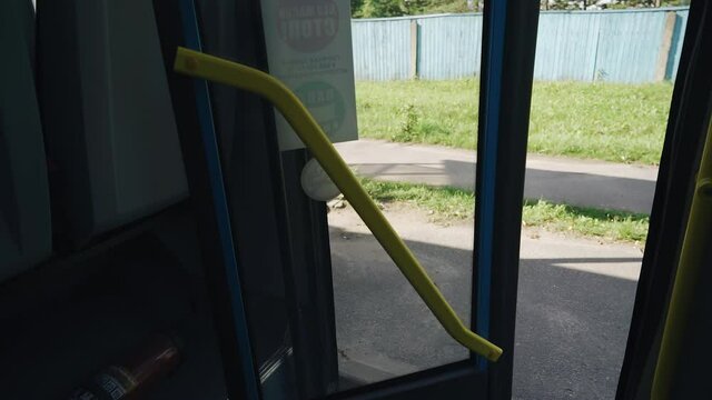 Shooting from inside a regular bus of the door opening process. The bus stopped at the bus stop