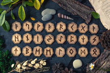 Wooden runes are lying on the table among various objects. Astrology and esotericism. Senior Futhark - obrazy, fototapety, plakaty